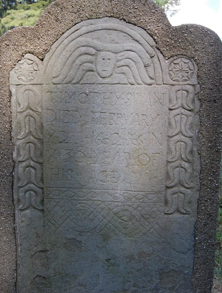 Timothy Swan's gravestone showing a face with wings over the inscription